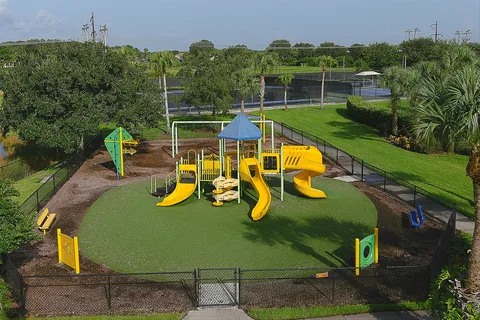 Colorful community playground surrounded by tropical landscaping