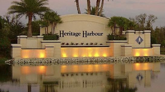 Illuminated Heritage Harbour entrance reflected in the water at dusk