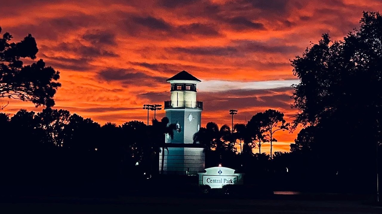 Central Park lighthouse silhouetted against a vivid Heritage Harbour sunset