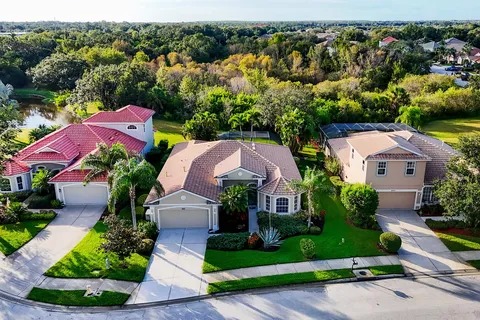 Aerial view of the home and its green residential surroundings