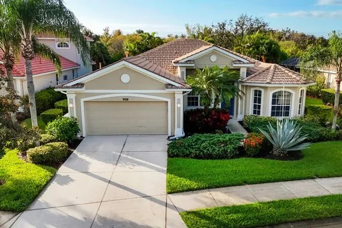 Front exterior of the Bradenton home with attached garage and tropical landscaping