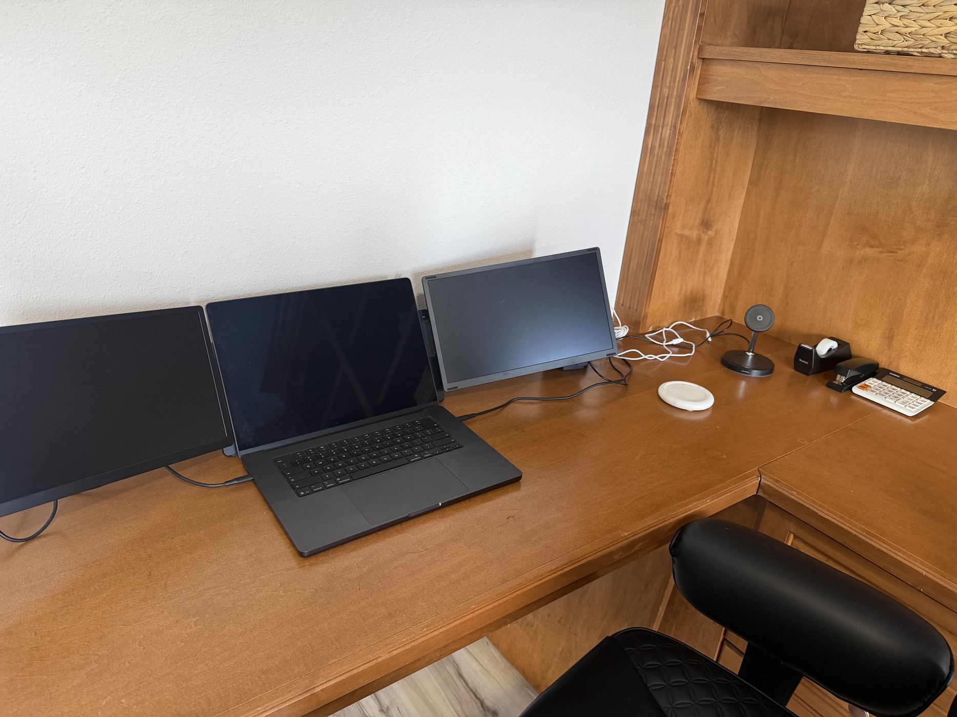Office desk configured with a laptop and two external monitors
