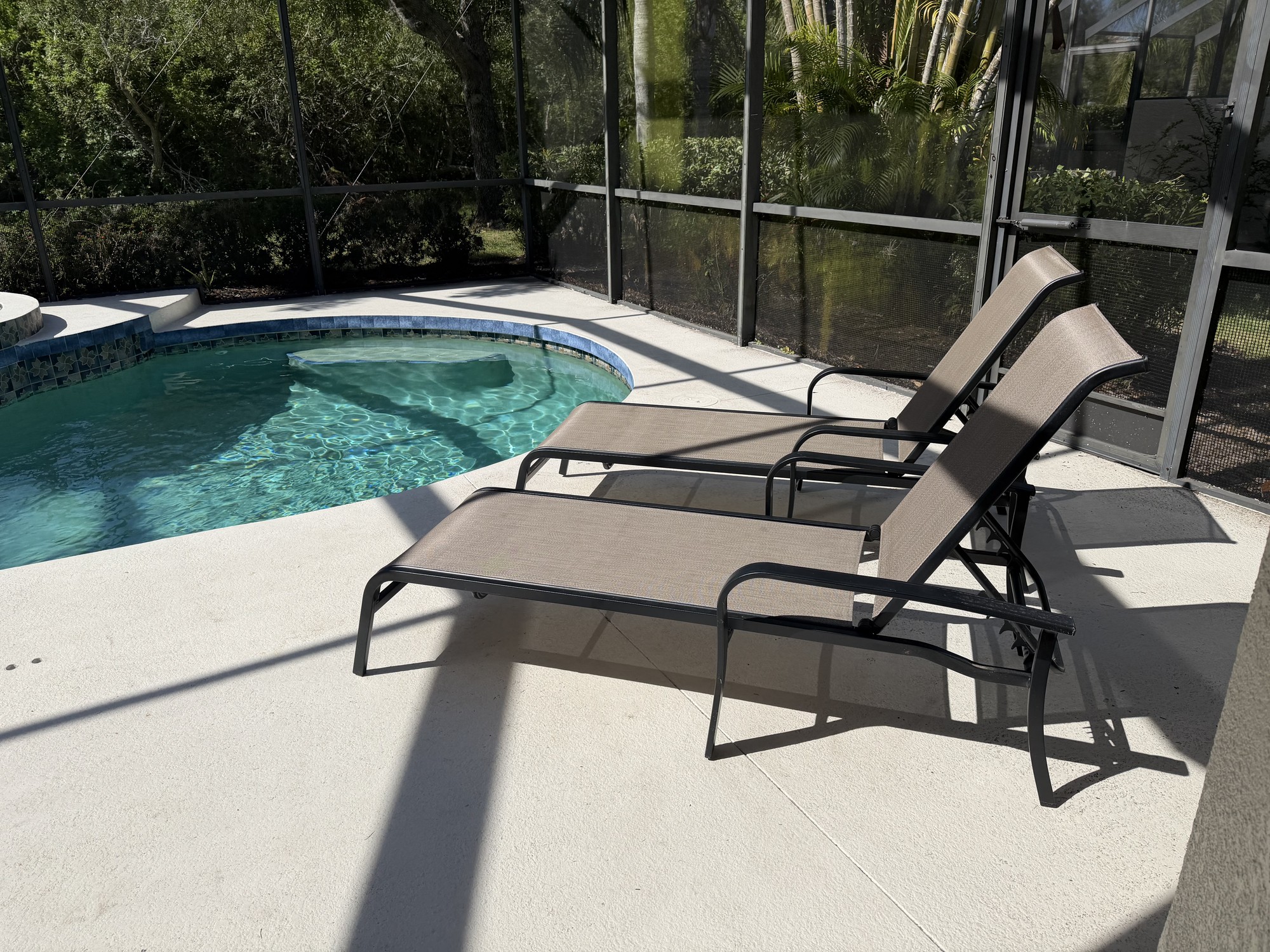 Two chaise lounges positioned beside the private pool and spa